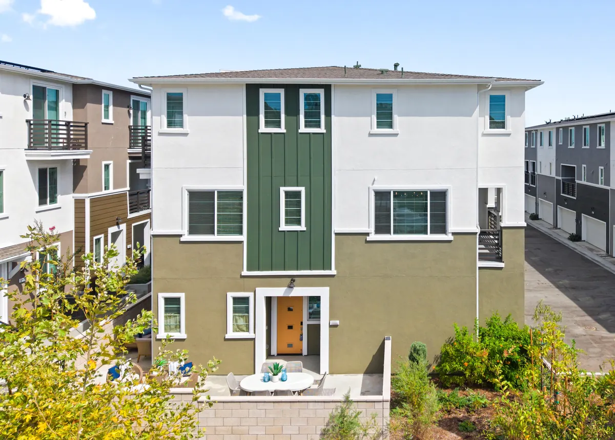 Three-story Cabrilla II townhome with white and olive-green facade at Ponte Vista