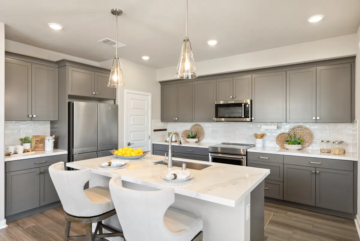 Model kitchen with gray cabinetry and a white island in a Cabrilla II home at Ponte Vista