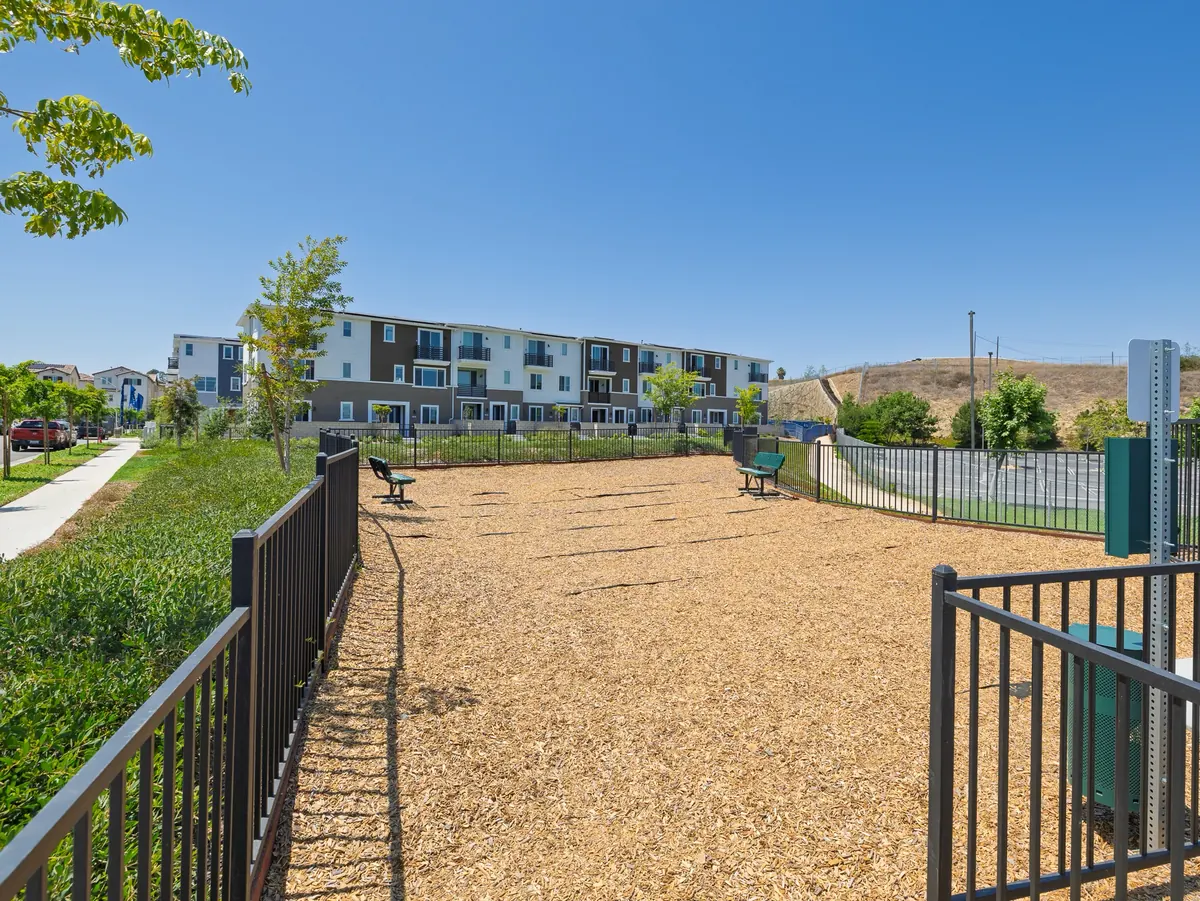 The fenced dog park seen from its gate, with homes nearby at Ponte Vista in San Pedro